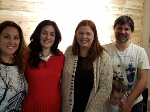 Mabel Salas posando con dos mujeres y un hombre que asistieron a sus charlas y formaciones presenciales sobre desarrollo personal